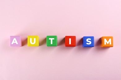 Photo of Word Autism made with colorful cubes on white background, top view