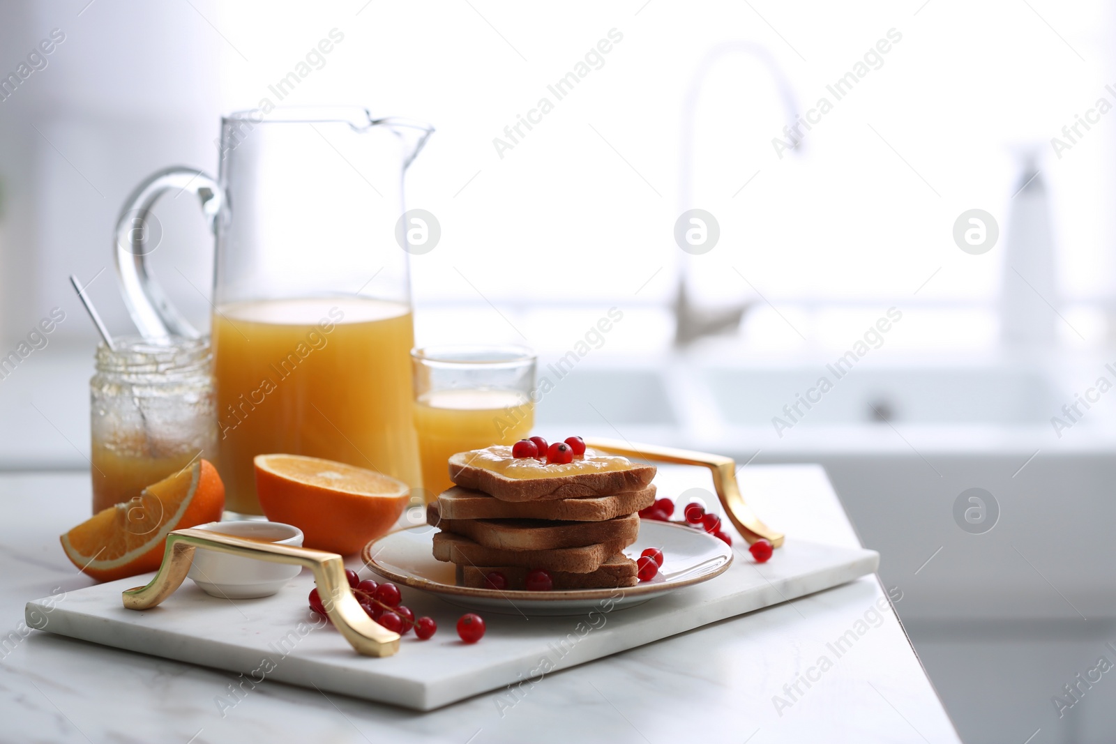 Photo of Toasted bread with jam and fresh cranberries on white table in kitchen, space for text