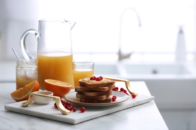 Toasted bread with jam and fresh cranberries on white table in kitchen, space for text