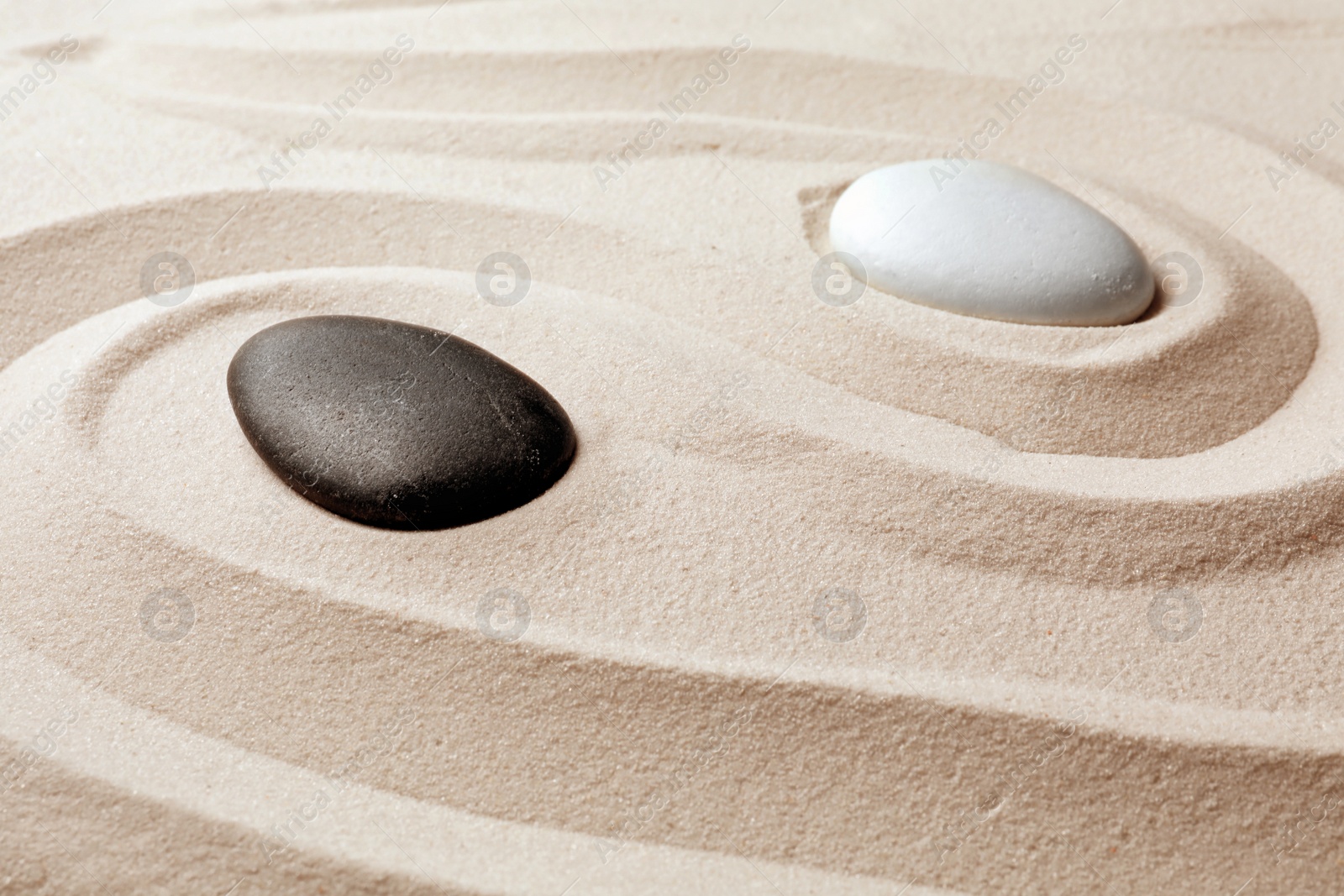 Photo of Zen garden stones on sand with pattern. Meditation and harmony