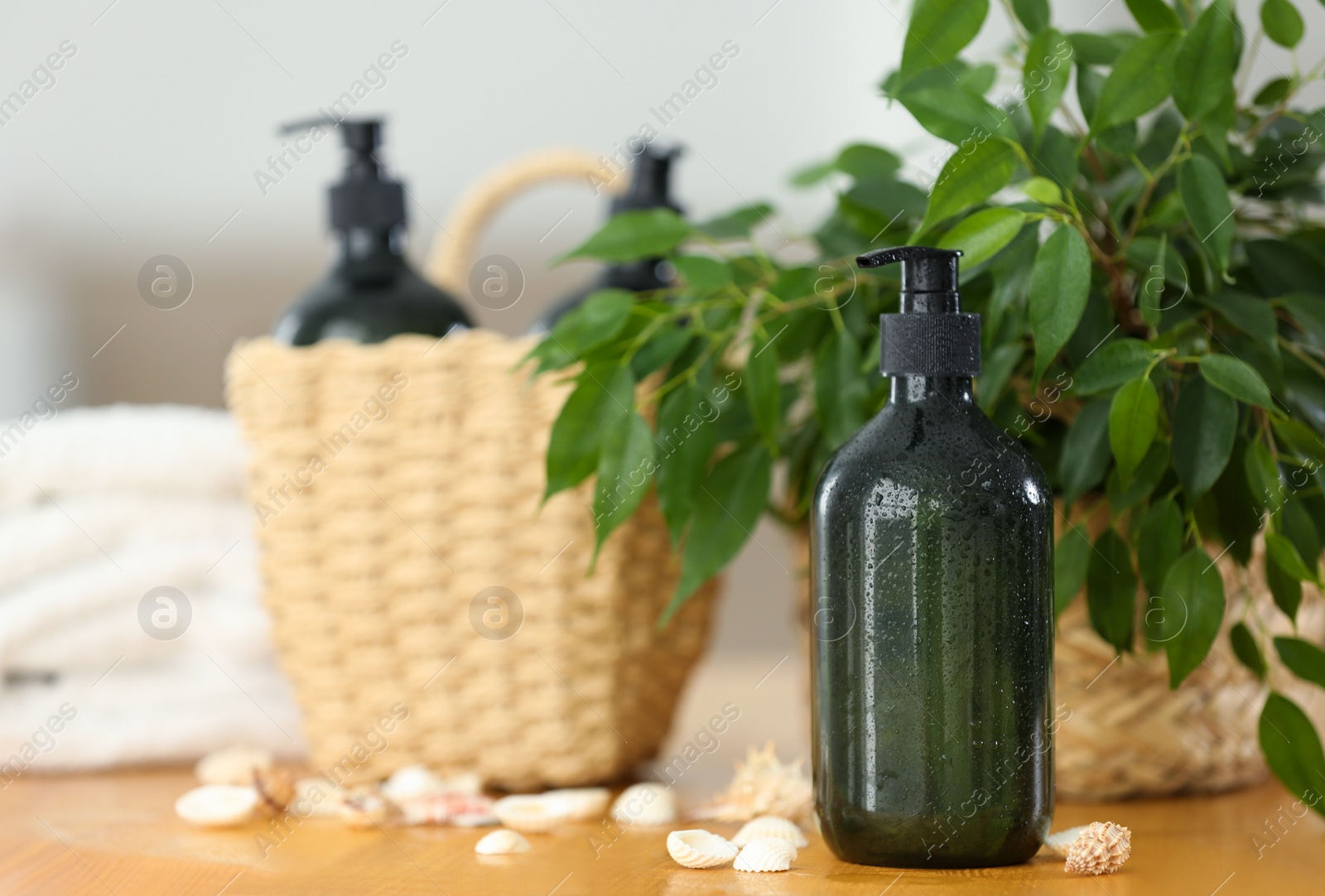 Photo of Soap dispensers and wicker basket on wooden table