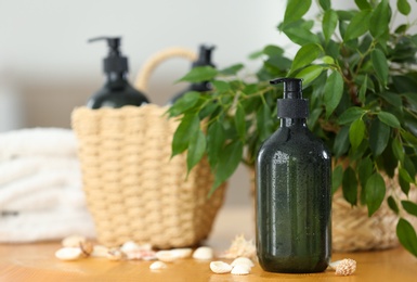 Soap dispensers and wicker basket on wooden table