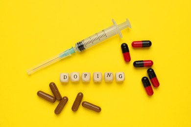 Wooden cubes with word Doping and drugs on yellow background, flat lay