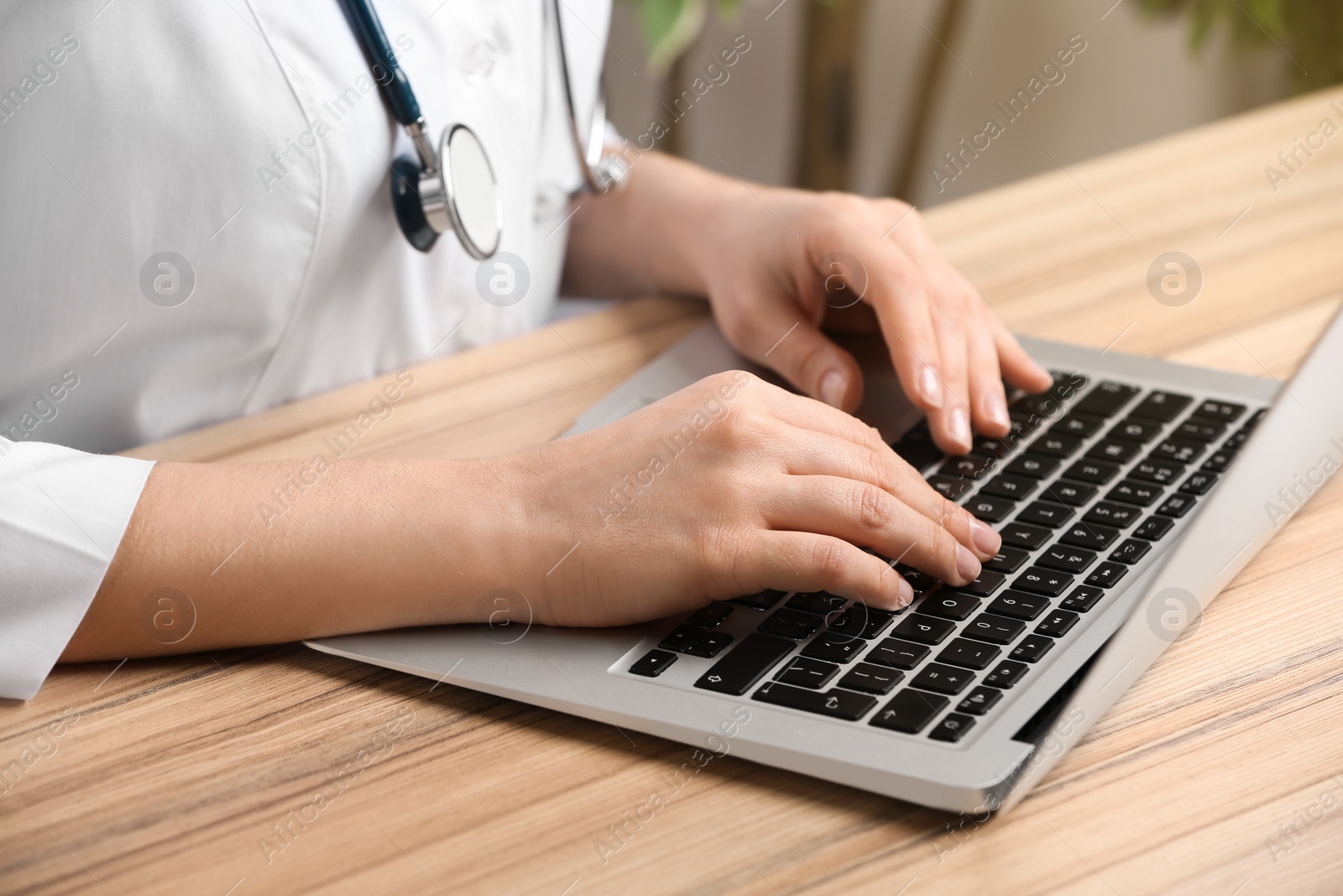 Photo of Doctor working with laptop at desk in office, closeup. Medical service