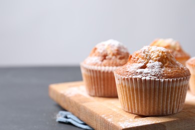 Photo of Delicious sweet muffins on black table, closeup. Space for text