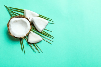 Ripe coconut with leaf on color background