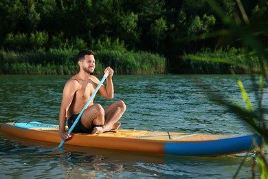 Photo of Man paddle boarding on SUP board in river
