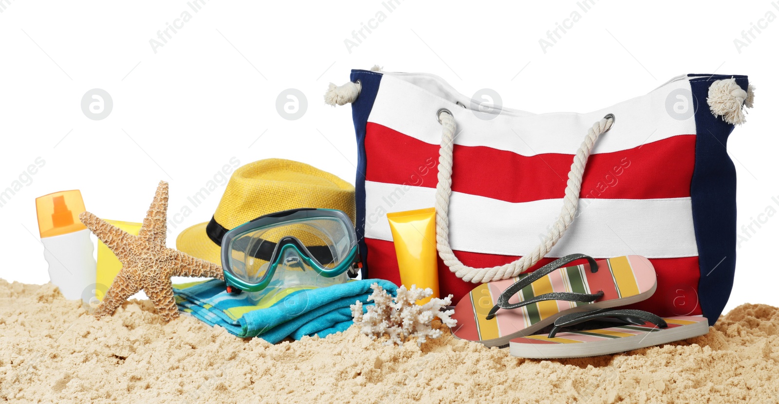 Photo of Stylish bag with beach accessories on sand against white background