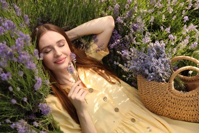 Photo of Young woman lying in lavender field on summer day