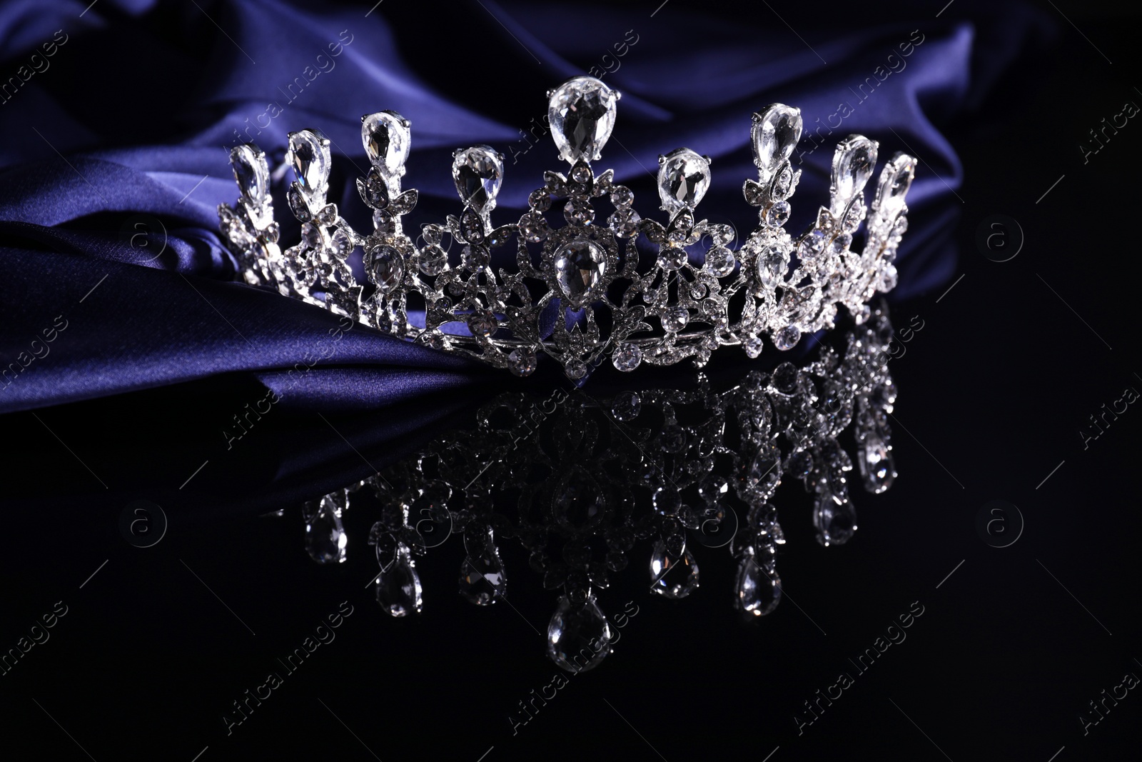 Photo of Beautiful silver tiara with diamonds on dark mirror surface