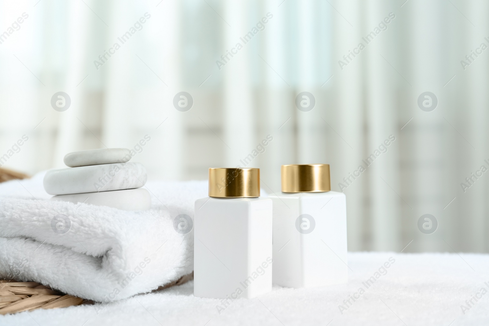 Photo of Composition with cosmetic products on white towel indoors, space for text. Spa therapy