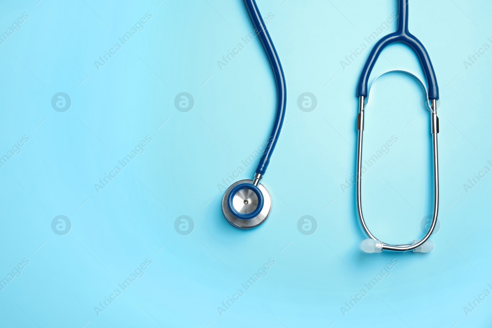 Photo of Stethoscope with space for text on color background, top view. Medical tool