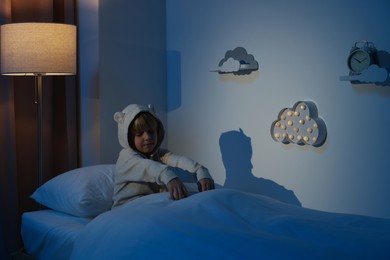 Boy in pajamas sleepwalking indoors at night