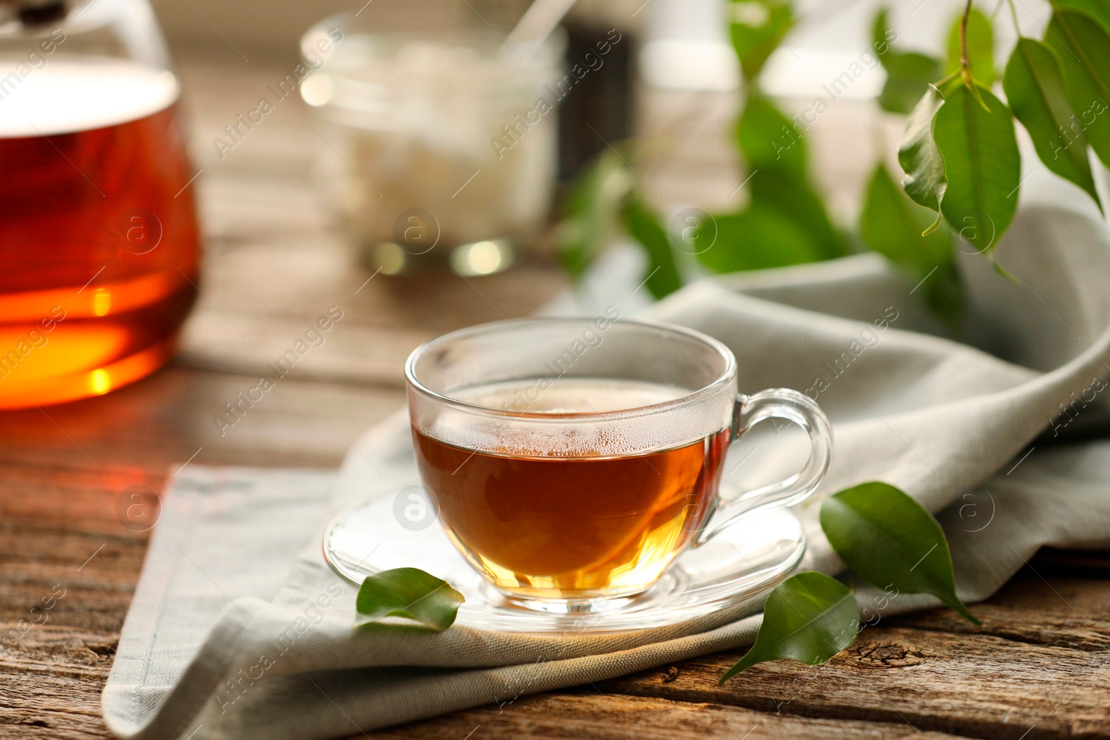 Photo of Tasty tea in cup on wooden table, closeup