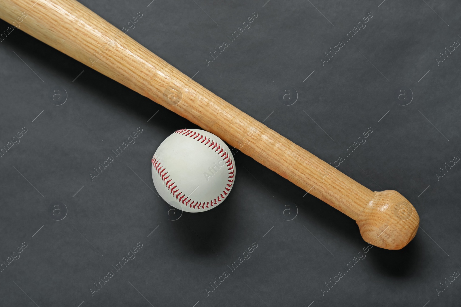 Photo of Wooden baseball bat and ball on black background, flat lay. Sports equipment