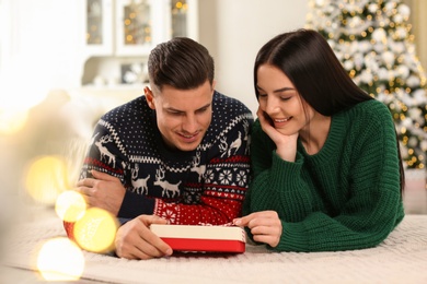 Happy couple with Christmas gift box at home