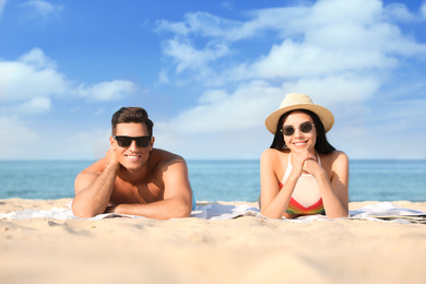 Photo of Happy couple resting on sunny beach at resort