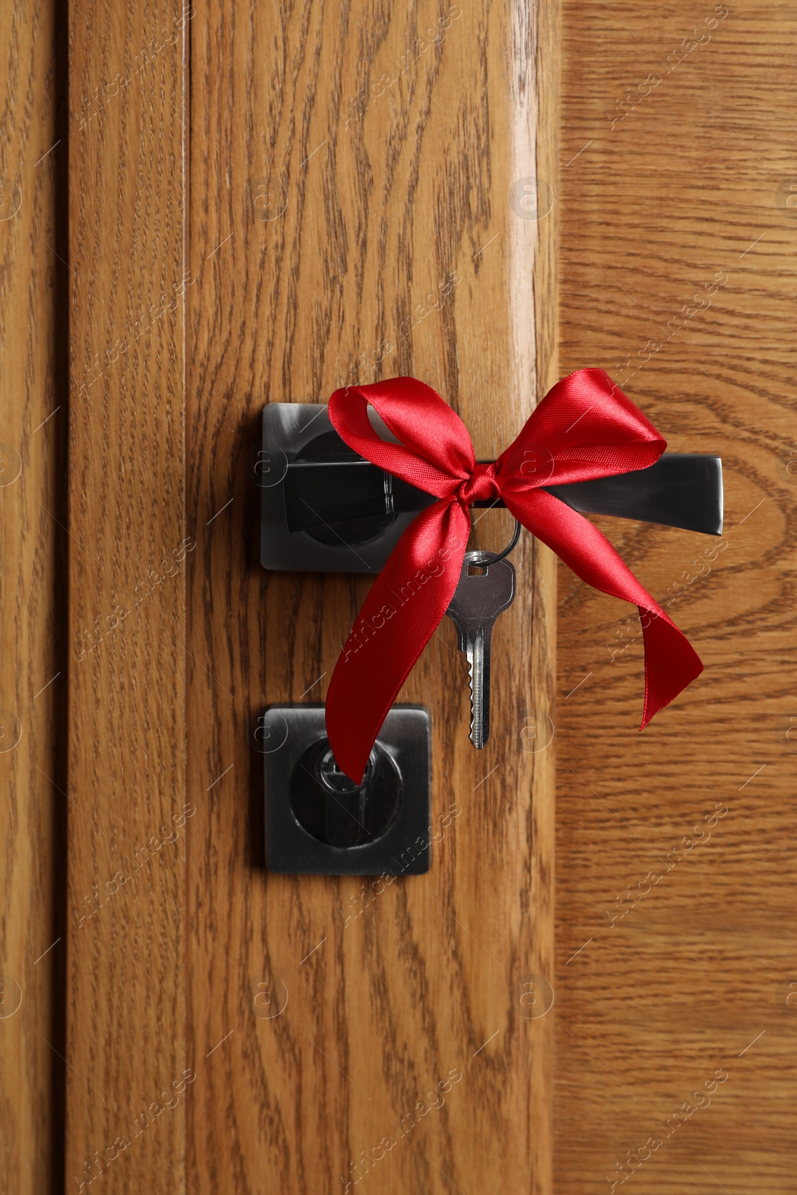 Photo of Key with red bow on door handle. Housewarming party