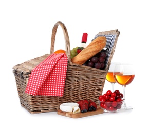Wicker picnic basket with wine and different products on white background