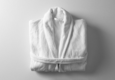 Photo of Clean folded bathrobe on white background, top view