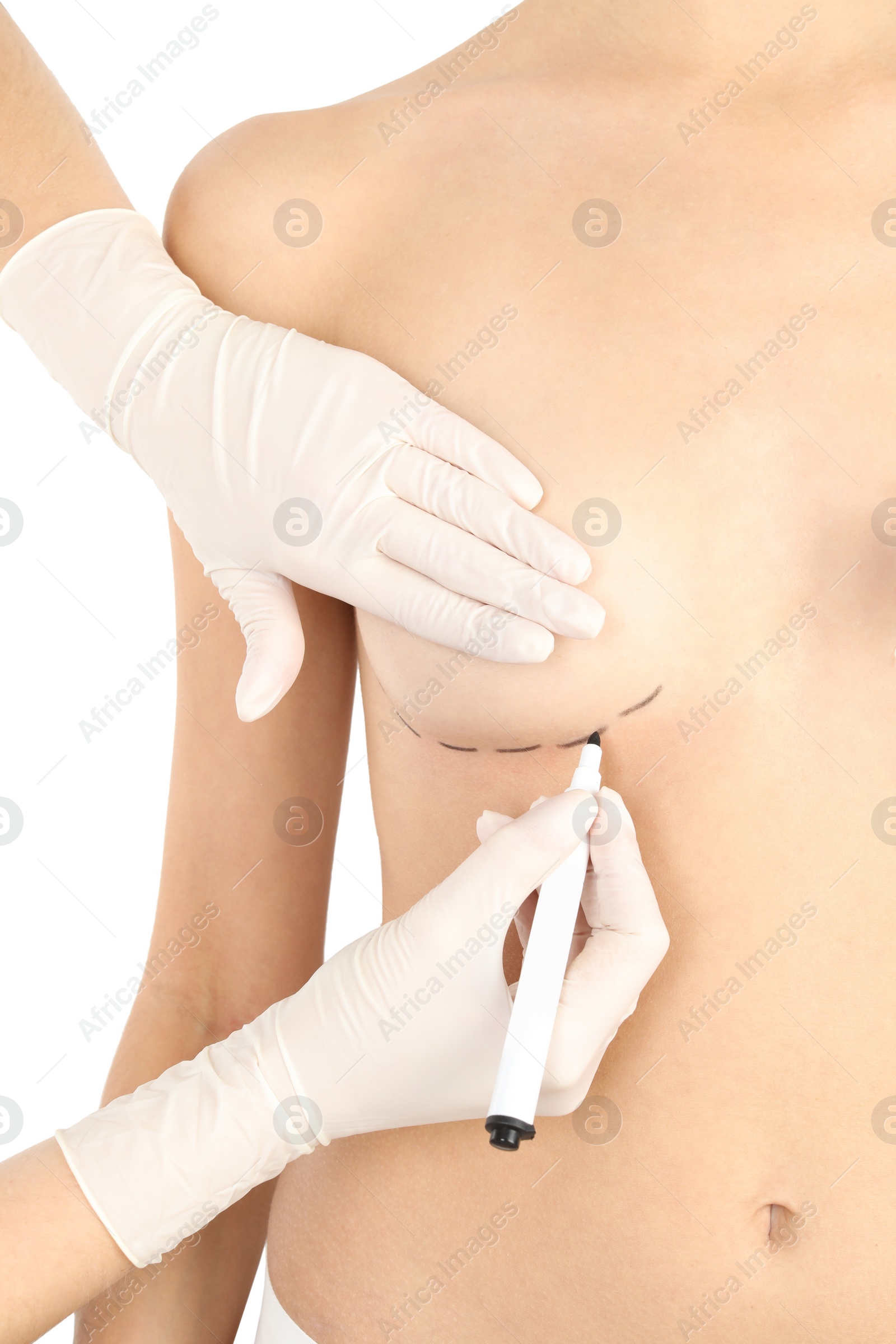 Photo of Doctor drawing marks on patient's breast for cosmetic surgery operation against white background, closeup