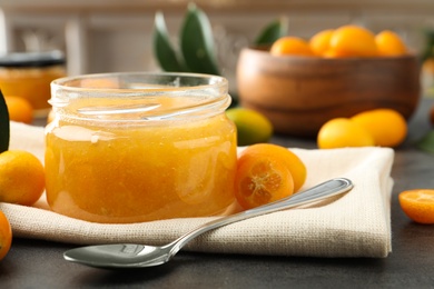 Photo of Delicious kumquat jam and fresh fruits on table, closeup