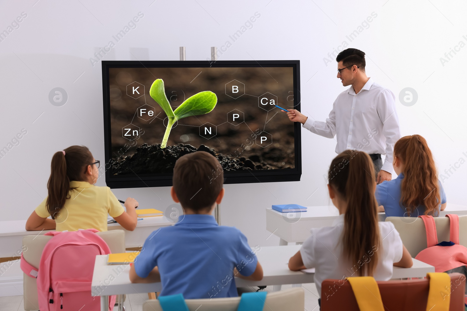 Photo of Teacher using interactive board in classroom during lesson
