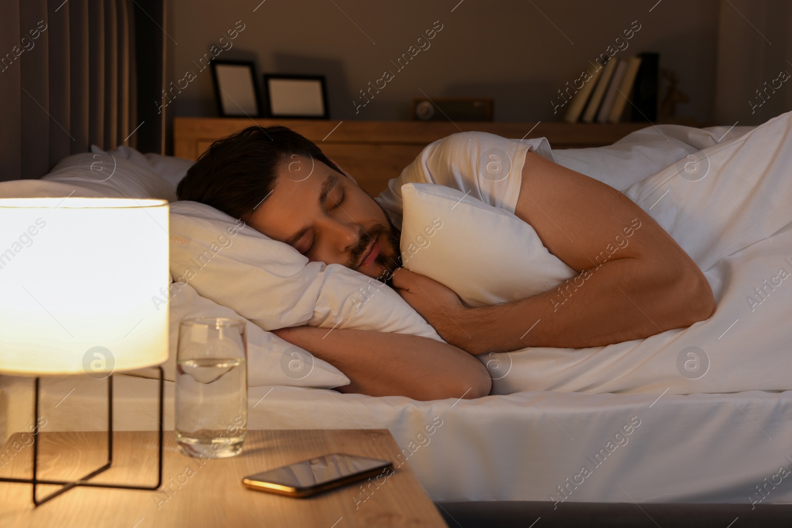 Photo of Handsome man sleeping in bed at night