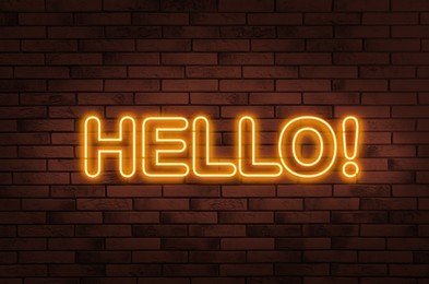 Image of Stylish neon sign with word Hello on brick wall