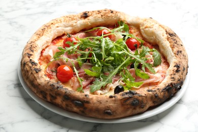 Photo of Tasty pizza with meat and arugula on white marble table