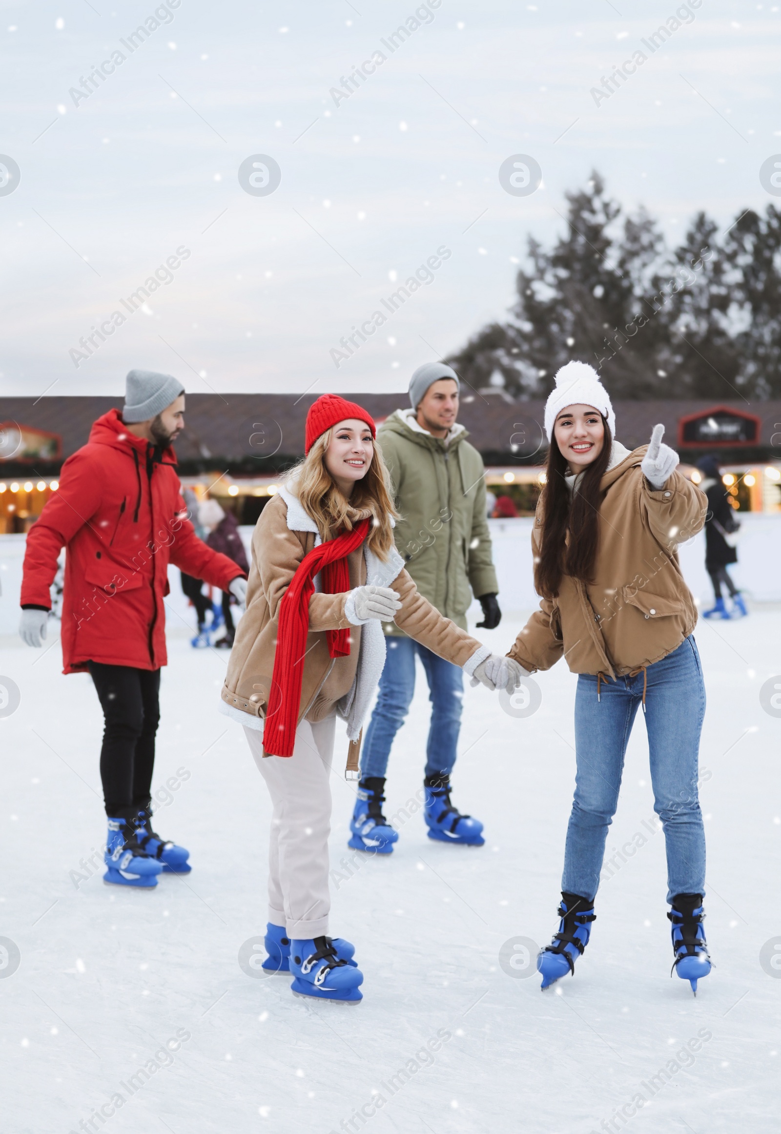 Image of Group of friends skating at outdoor ice rink