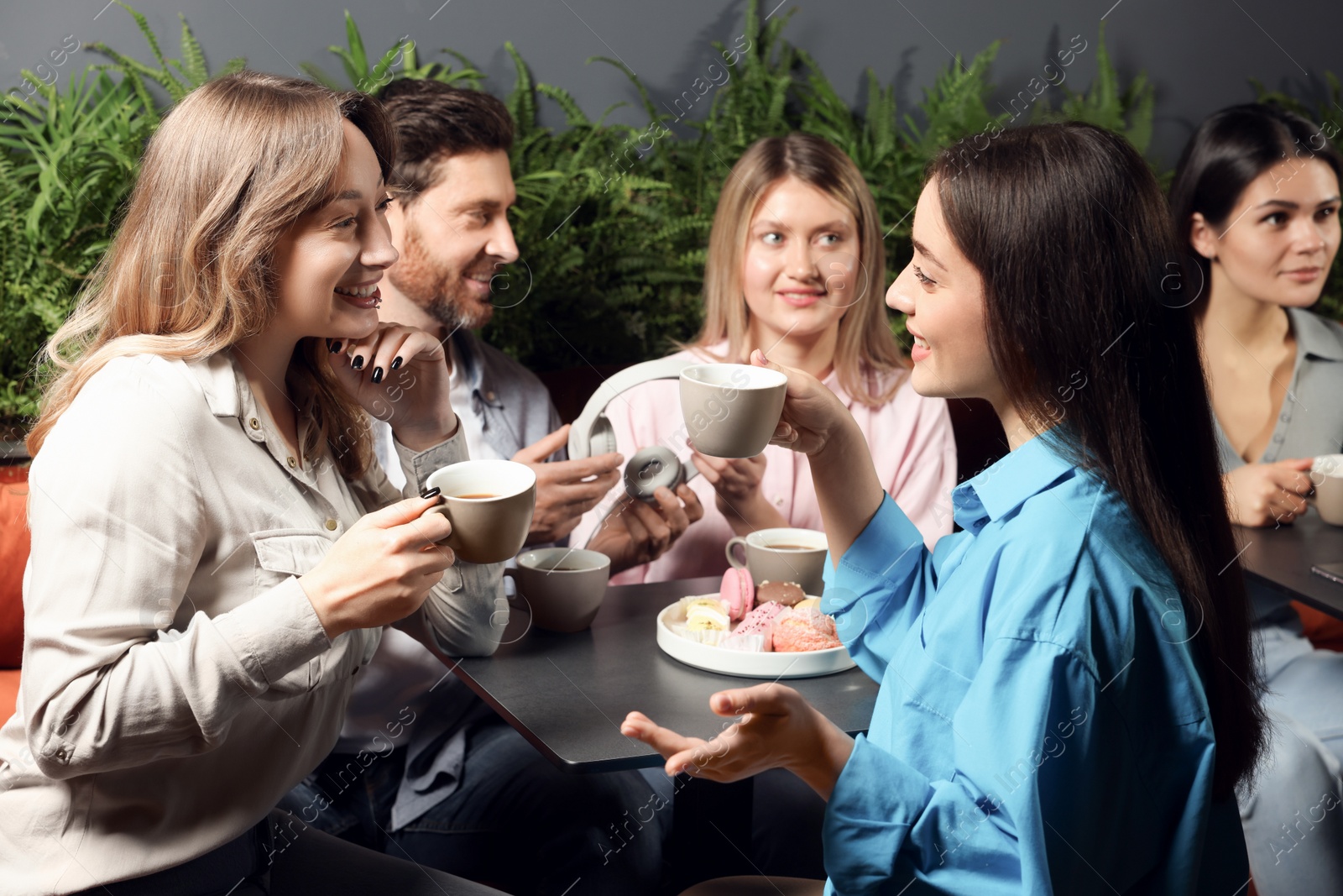 Photo of Friends with coffee spending time together in cafe