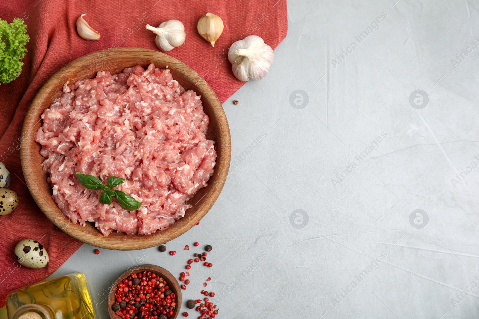 Photo of Raw chicken minced meat and ingredients on grey table, flat lay. Space for text
