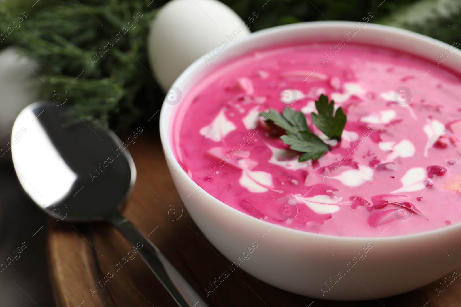 Photo of Delicious cold summer beet soup on wooden board, closeup