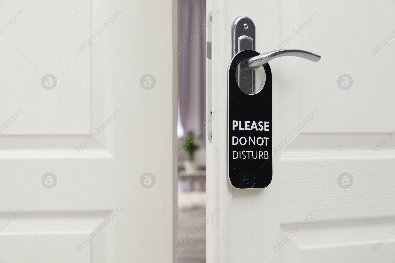 Photo of Open door with sign PLEASE DO NOT DISTURB on handle at hotel
