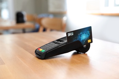 Credit card machine for non cash payment on wooden table indoors