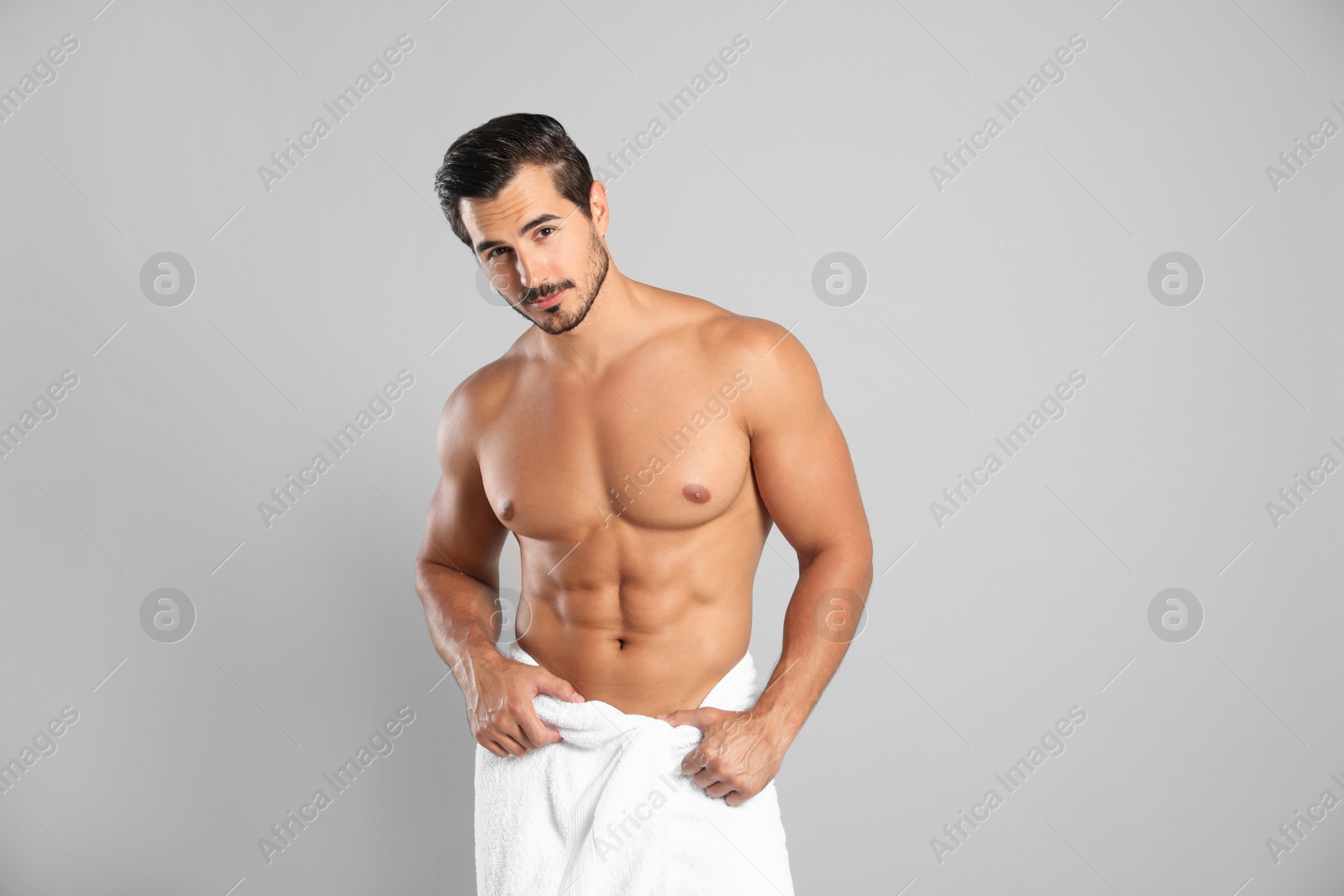 Photo of Young man with slim body on grey background