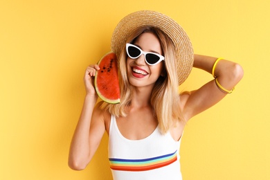 Pretty young woman with juicy watermelon on color background