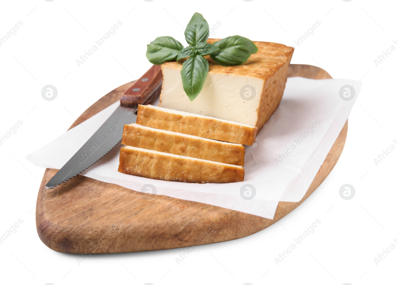 Photo of Wooden board with smoked tofu, knife and basil on white background