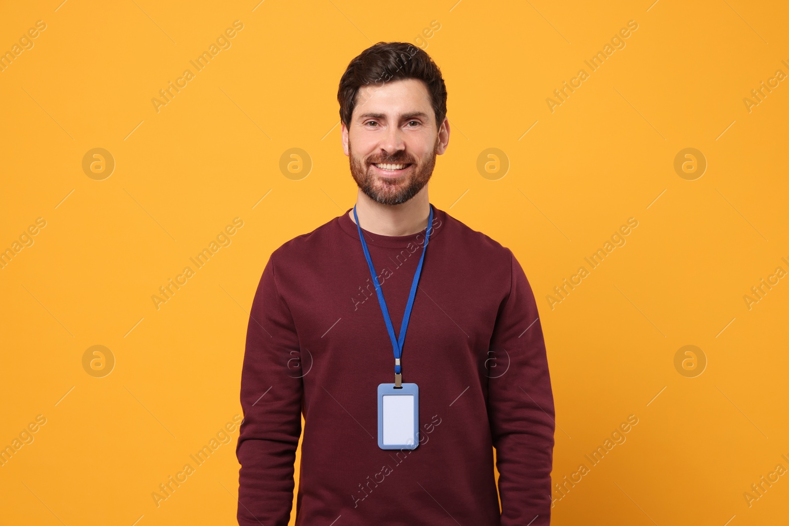 Photo of Smiling man with VIP pass badge on orange background