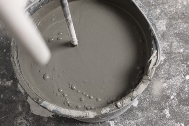 Photo of Mixing concrete in bucket indoors, closeup view