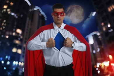Image of Businessman wearing superhero costume and beautiful cityscape in night on background