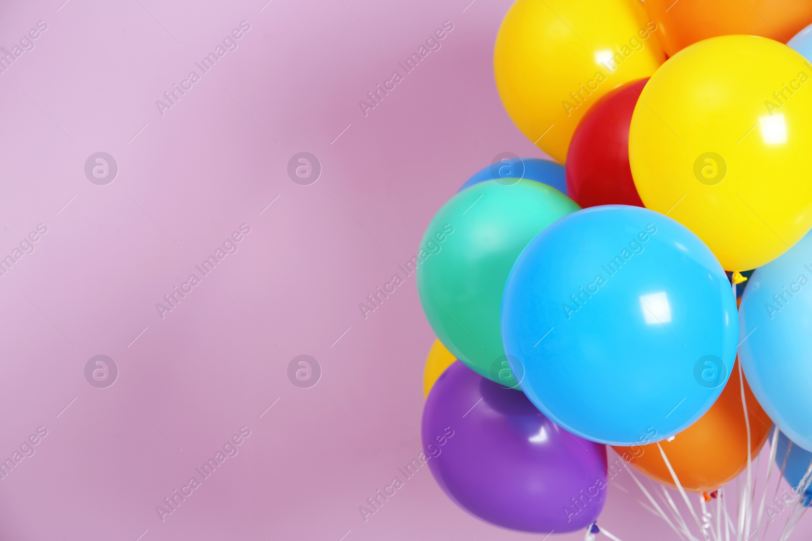 Photo of Bunch of bright balloons and space for text against color background