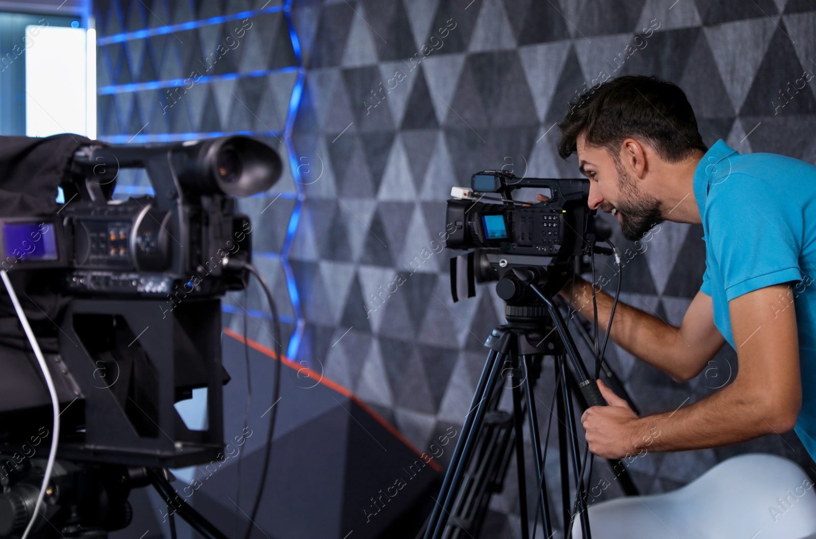 Photo of Professional video camera operator working in studio