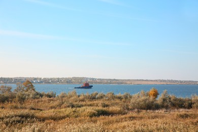 Picturesque view of river with tugboat and beautiful shore