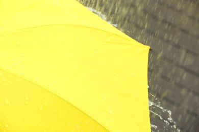 Photo of Bright color umbrella under rain outdoors, closeup