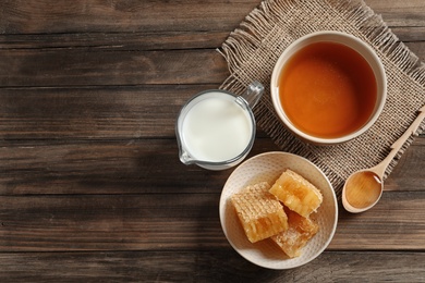 Photo of Composition with milk and honey on wooden background, top view