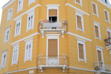 View of beautiful yellow building with balconies outdoors