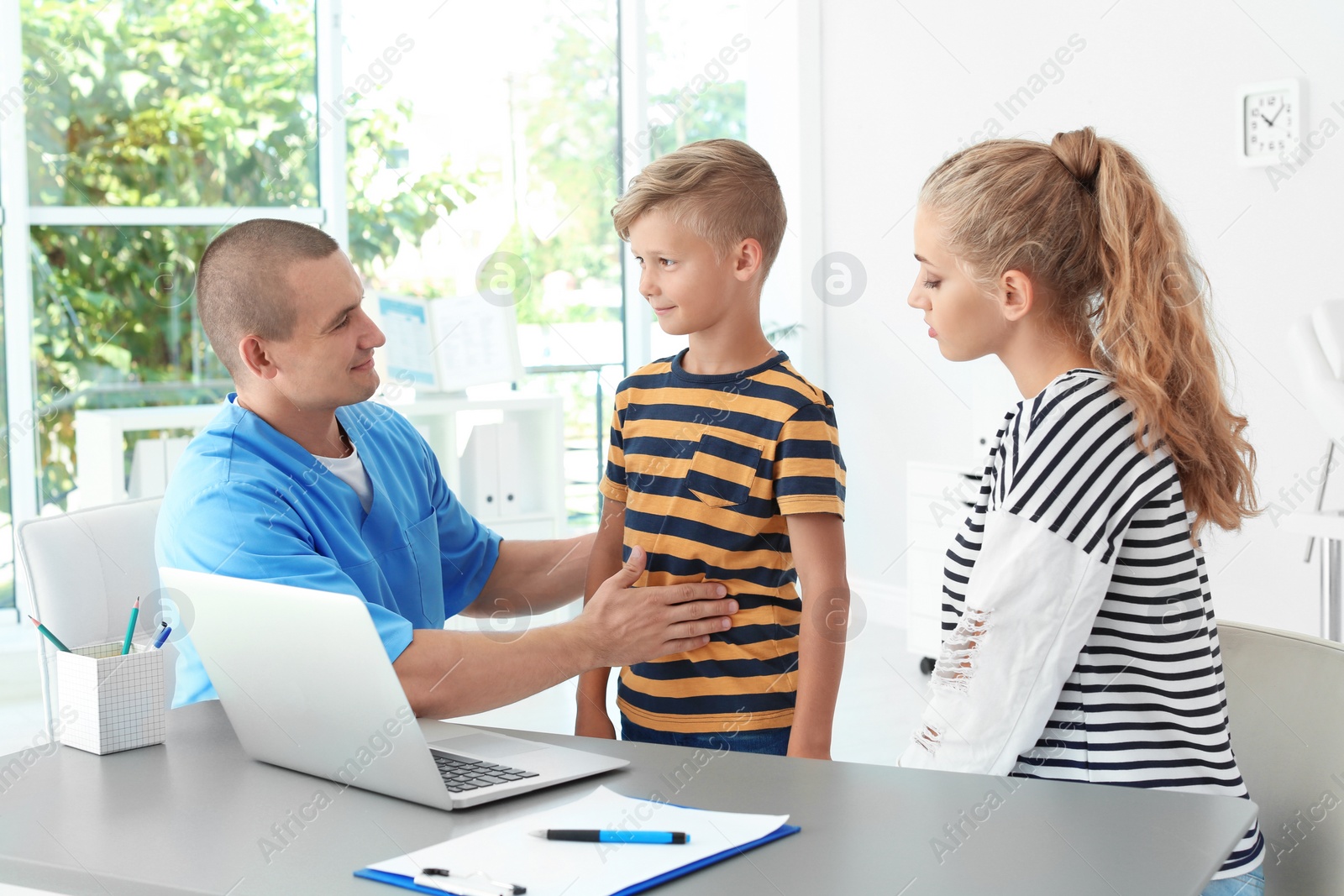 Photo of Male medical assistant consulting mother with son in clinic