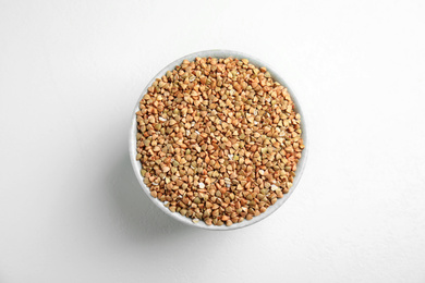 Photo of Bowl with green buckwheat on white table, top view